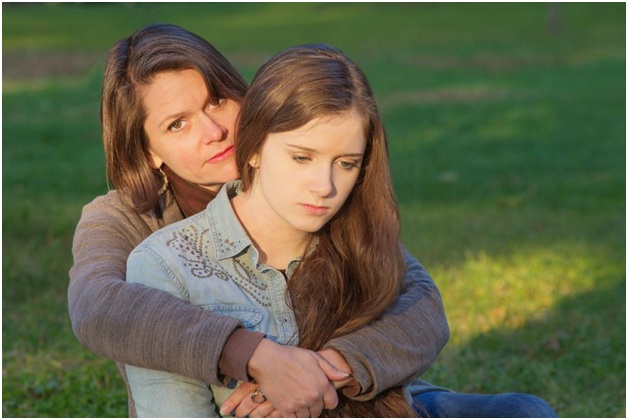 A mother holding her worried daughter closely